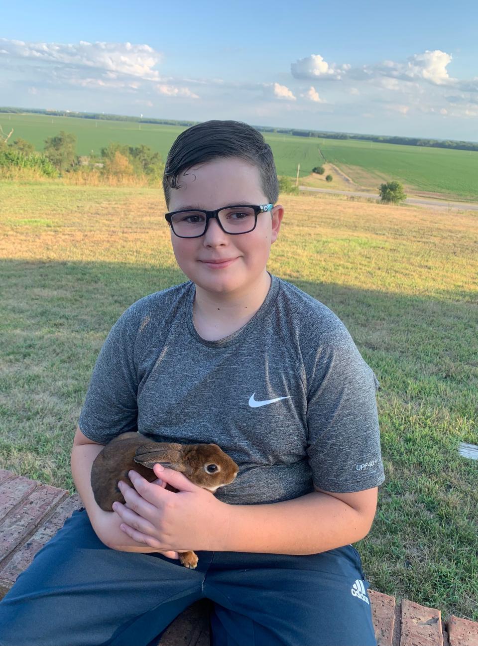 Caleb Schlatter with one of the rabbits he raises and shows.