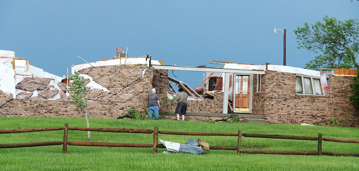 Homeowners look around the damage after a tornado touched down in Nevada, Iowa on Tuesday, May 21, 2024.