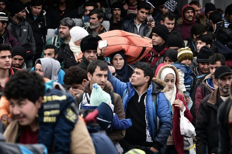 Hundreds of migrants disembark from a ferry at the port of Piraeus on February 10, 2016