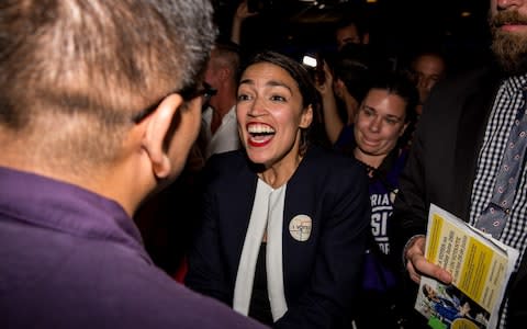 Progressive challenger Alexandria Ocasio-Cortez celebrartes with supporters at a victory party in the Bronx  - Credit: Getty