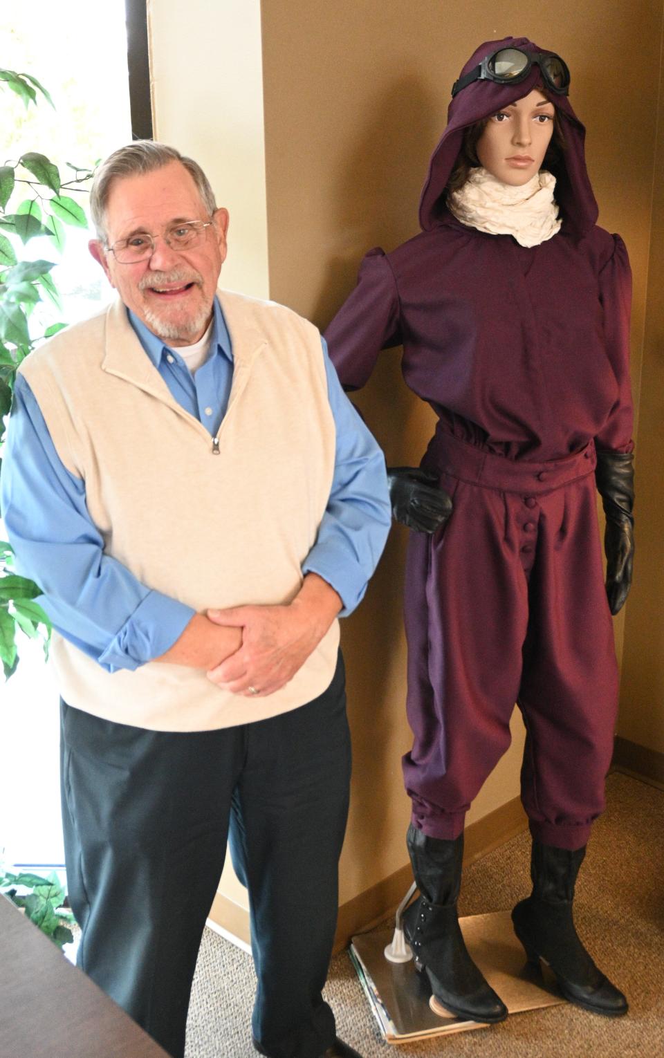 Flying Club president Tom Fisher with the replica flight suit designed by pioneer pilot Harriet Quimby whose family came from Branch County.