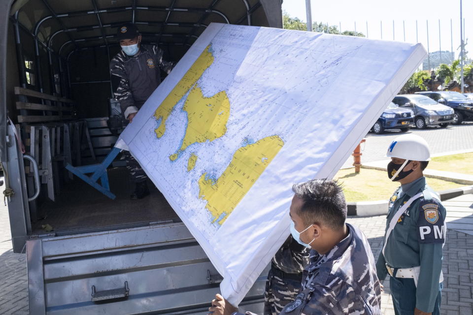 Military personnel load a map of the search area for the missing submarine onto a truck at Ngurah Rai Airport in Bali.