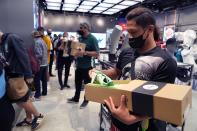 A customer examines his Superstar Ravi sneaker at the Adidas showroom in Dubai, United Arab Emirates, Thursday, June 23, 2022. Adidas has teamed up with Dubai nostalgic family-owned Pakistani restaurant to release the Superstar Ravi sneaker. (AP Photo/Kamran Jebreili)