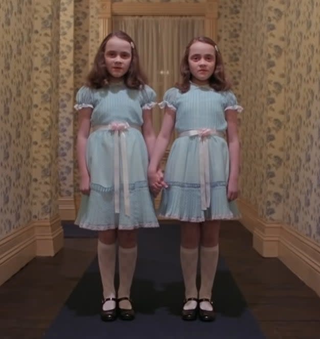the twins holding hands in the hallway