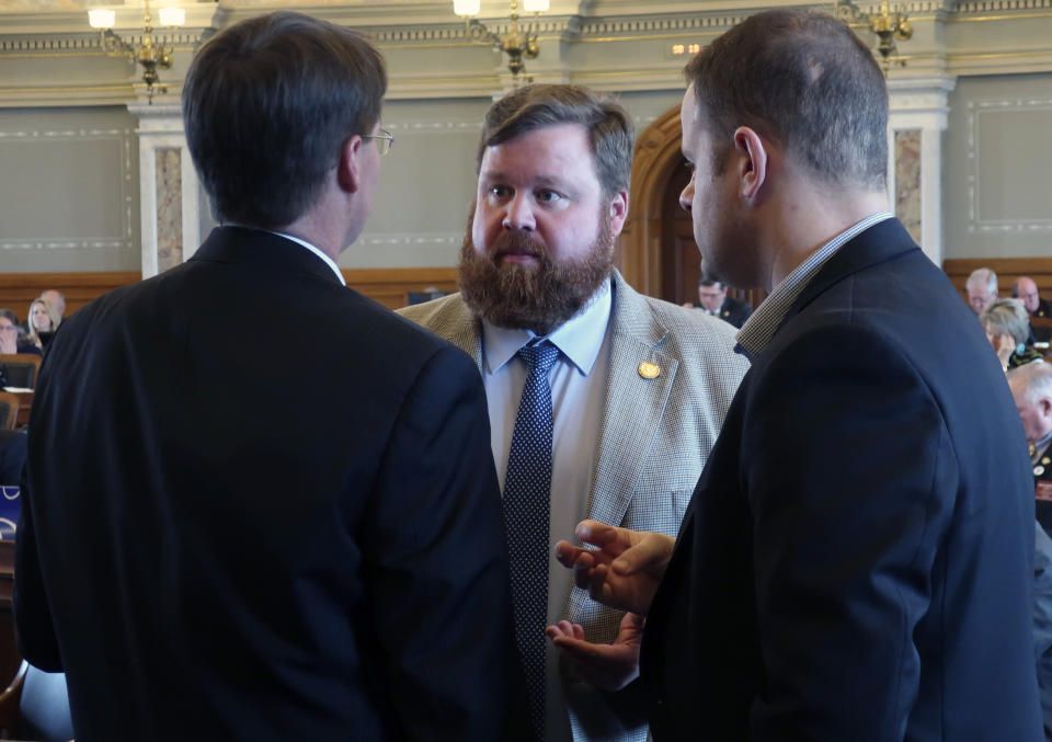Kansas House Speaker Pro Tem Blaine Finch, center, confers with Rep. Fred Patton, left, R-Topeka, and B.J. Harden, the chief of staff to the House Majority Leader, during a debate, Friday, April 5, 2019, at the Statehouse in Topeka, Kan. Lawmakers have passed a bill to allow the Kansas Farm Bureau to sell health coverage to its members that doesn't comply with the federal Affordable Care Act. (AP Photo/John Hanna)