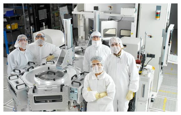 Semiconductor workers pose for a picture in a clean room.