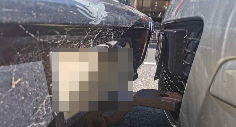 A photo of the bumpers of two cars almost touching, with the tow bar of one vehicle hitting the grille of the other. A Sydney driver shared her frustration over the stranger's parking job.