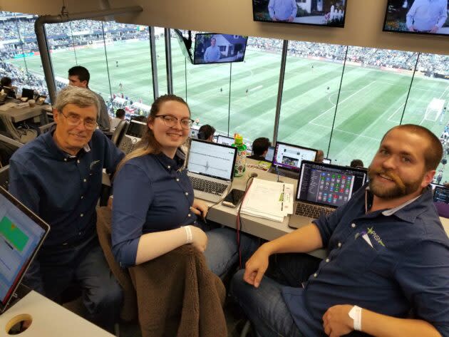 Members of the Pacific Northwest Seismic Network’s team take up their stations for the Seattle vs. Toronto championship soccer match inside the press box at CenturyLink Field. From left are Steve Malone, Elizabeth Urban and Mickey Cassar. (GeekWire Photo / Taylor Soper)