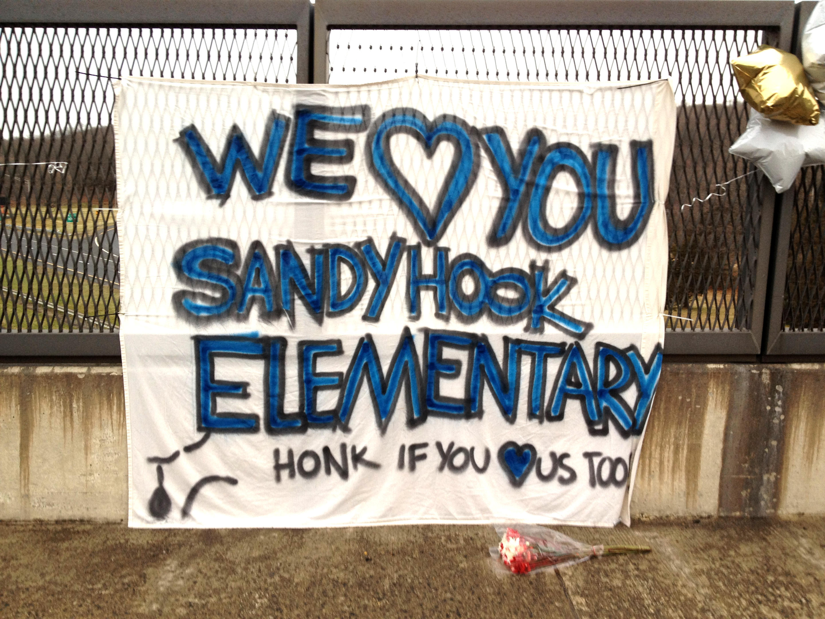 A banner hangs on the side of a highway overpass in Newtown, Conn., Dec. 16, 2012. (Dylan Stableford/Yahoo News)