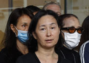 Pansy Ho, center, daughter of Macau tycoon Stanley Ho speaks to the press with Ho's family members outside a hospital, Hong Kong, Tuesday, May 26, 2020. Stanley Ho, the dashing billionaire and bon vivant who was considered the father of modern gambling in China, has died, his daughter Pansy Ho said Tuesday. He was 98. (AP Photo/Kin Cheung)