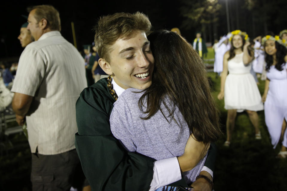 Sean Newsom hugs his mother, Melissa after graduation ceremonies at Paradise High School in Paradise, Calif., Thursday June 6, 2019. After the Camp Fire destroyed the family home in Paradise, Calif. his parents relocated to the San Francisco Bay Area and Newsom moved to an apartment with his older brother in Chico to finish his senior year. Newsom and the rest of of the Paradise High School Class of 2019 gathered one more time for graduation (AP Photo/Rich Pedroncelli)