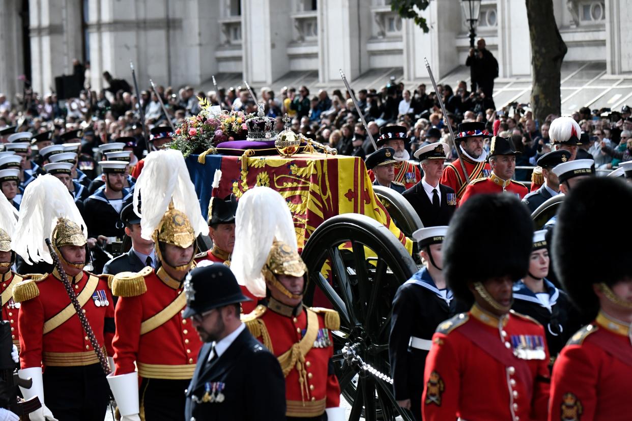 The State Gun Carriage carries the coffin of Queen Elizabeth II, draped in the Royal Standard with the Imperial State Crown and the Sovereign's orb and sceptre, in the Ceremonial Procession following her State Funeral at Westminster Abbey, London. Picture date: Monday September 19, 2022.