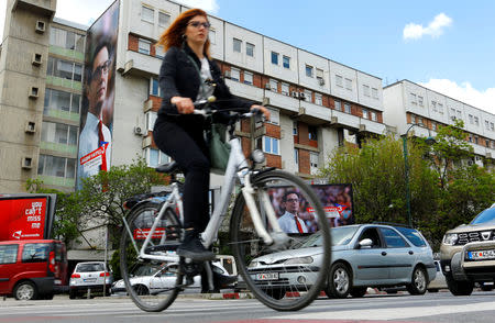 A woman passes election campaign posters of the ruling party candidate Stevo Pendarovski for presidential election on April 21 in Skopje, North Macedonia April 19, 2019. REUTERS/Ognen Teofilovski