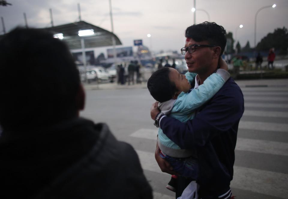 In this Monday, Nov. 28, 2016 photo, a Nepali migrant worker Krishna Bahadur Tamang, 32, carries his son before departing for Qatar at Tribhuwan Internation airport in Kathmandu, Nepal. The number of Nepali workers going abroad has more than doubled since the country began promoting foreign labor in recent years: from about 220,000 in 2008 to about 500,000 in 2015. Yet the number of deaths among those workers has risen much faster in the same period. In total, over 5,000 workers from this small country have died working abroad since 2008, more than the number of U.S. troops killed in the Iraq War. (AP Photo/Niranjan Shrestha)
