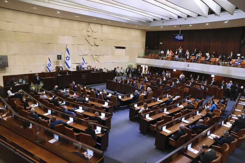 Israeli lawmakers attend the swearing-in ceremony for Israel's 24th government, at the Knesset, or parliament, in Jerusalem, Tuesday, April 6, 2021. The ceremony took place shortly after the country's president asked Prime Minister Benjamin Netanyahu to form a new majority coalition, a difficult task given the deep divisions in the fragmented parliament. (Alex Kolomoisky/Pool via AP)
