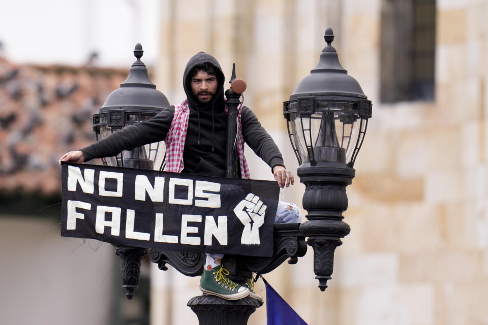 A supporter of new Colombia's President Gustavo Petro displays a sign reading in Spanish "Don't let us down" prior to his swearing-in ceremony at the Bolivar square in Bogota, Colombia, Sunday, Aug. 7, 2022.(AP Photo/Fernando Vergara)