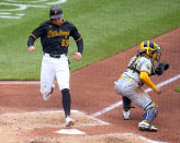 Pittsburgh Pirates' Jack Suwinski (65) scores from second on a single by Jared Triolo off Milwaukee Brewers starting pitcher Freddy Peralta during the fifth inning of a baseball game in Pittsburgh, Thursday, April 25, 2024. Waiting for the late relay throw is catcher William Contreras. (AP Photo/Gene J. Puskar)