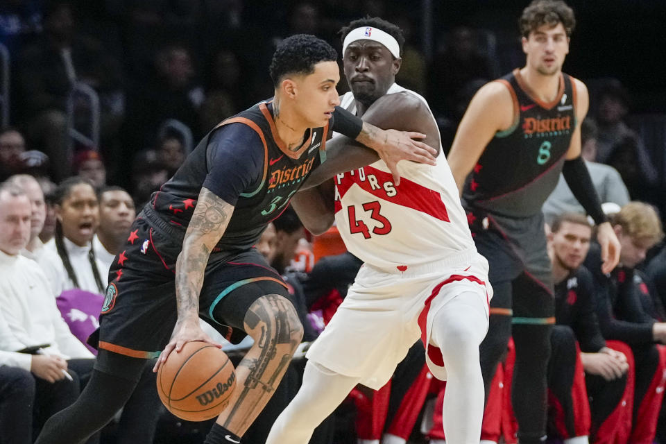 Washington Wizards forward Kyle Kuzma (33) drives past Toronto Raptors forward Pascal Siakam (43) during the first half of an NBA basketball game Wednesday, Dec. 27, 2023, in Washington. (AP Photo/Alex Brandon)