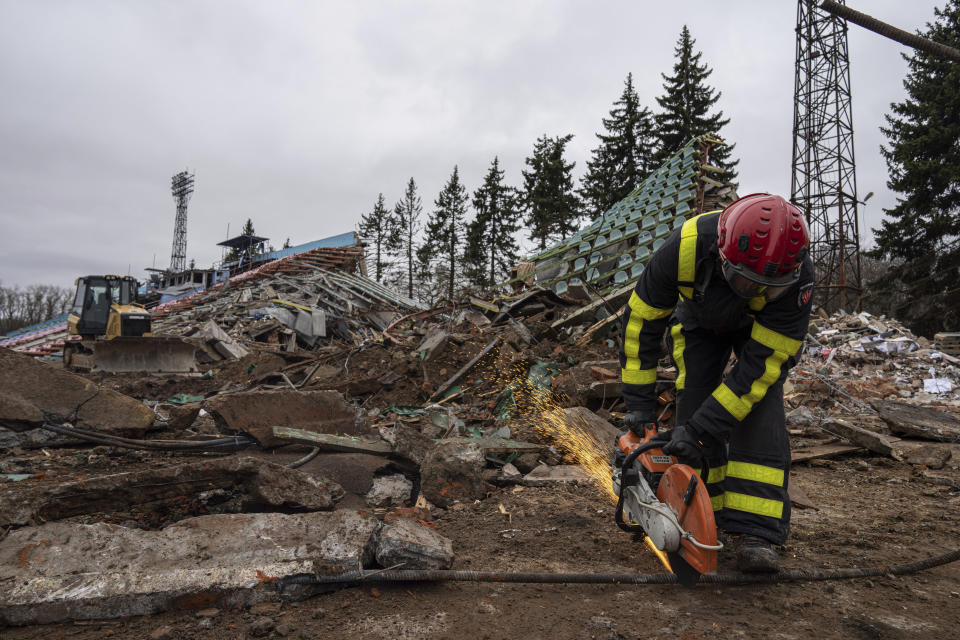 A firefighter works at a central stadium damaged by Russian forces' shelling in Chernihiv, Ukraine, Wednesday, April 13, 2022. (AP Photo/Evgeniy Maloletka)