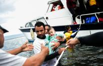 Migrant families disembark on the Greek island of Lesbos after crossing the Aegean Sea from Turkey, on November 25, 2015