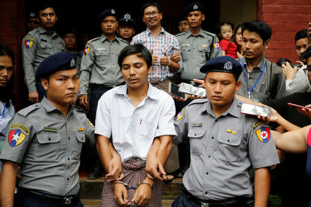 Detained Reuters journalists Kyaw Soe Oo and Wa Lone are escorted by police as they leave after a court hearing in Yangon, Myanmar, August 20, 2018. REUTERS/Ann Wang/File Photo