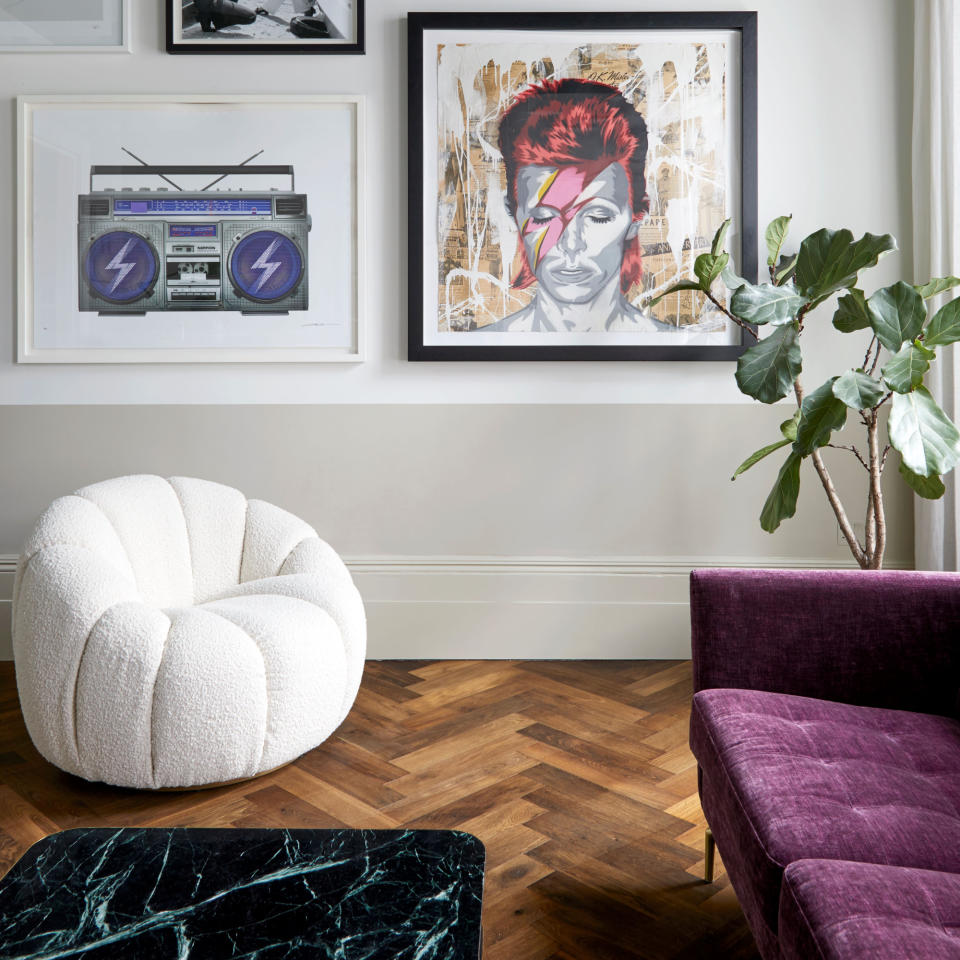 White painted living room with green ceiling, wooden flooring, marble coffee table, boucle armchair and purple sofa