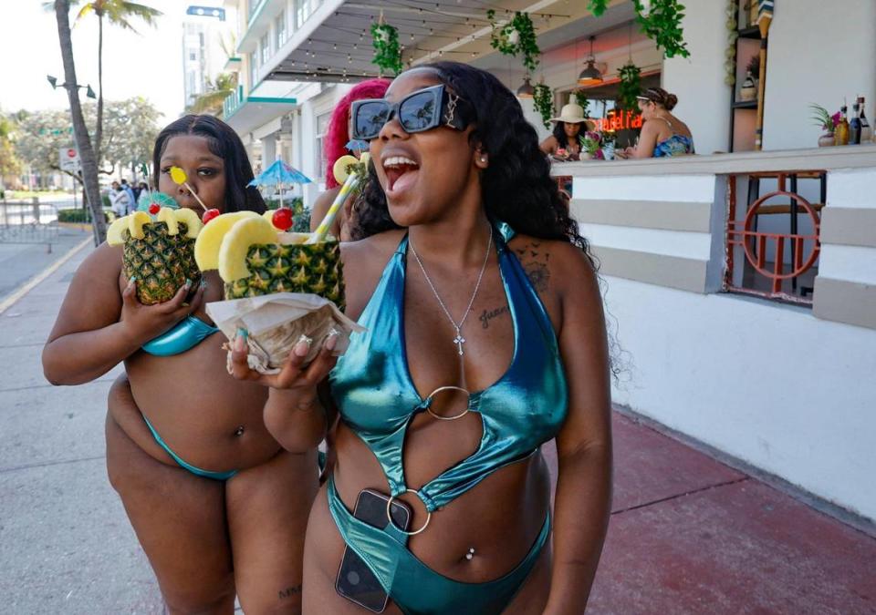 Andira Fullnz, of Virginia, with friends drinking from a tropical pineapple while walking along Ocean Drive during spring break on Miami Beach, Florida on Saturday, March 16, 2024.