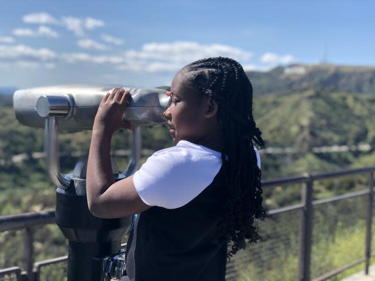 Avery Jenkins, 9, of Atlanta peers through a scope at Griffith Park Observatory during her family's visit to Los Angeles.