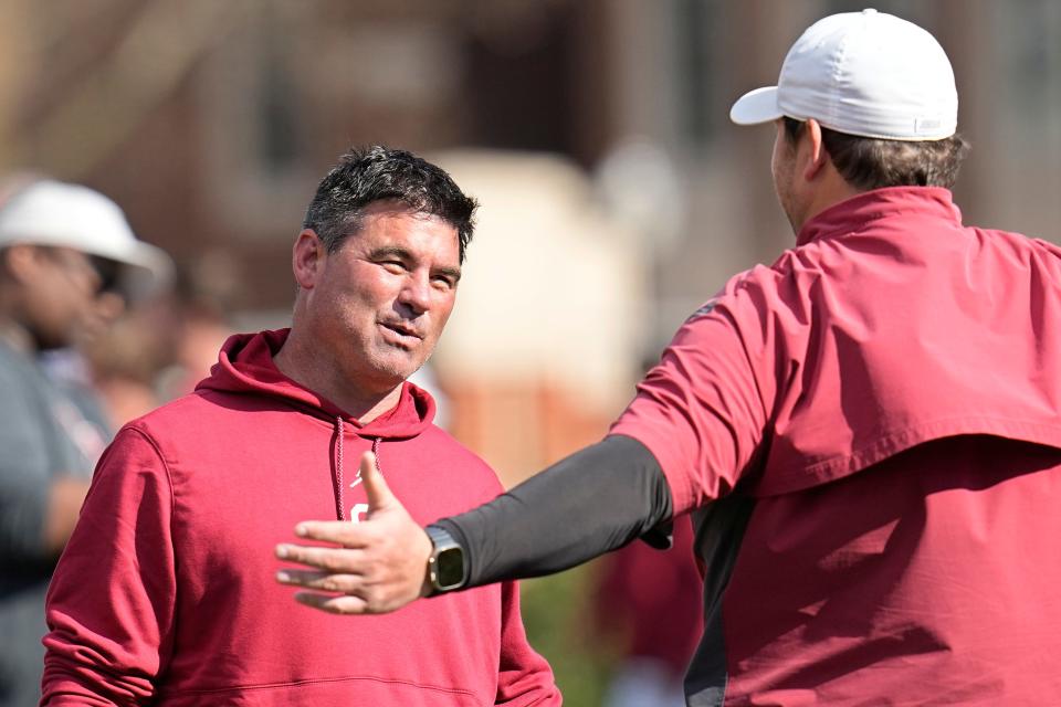 New OU offensive coordinator Seth Littrell, left, talks with former Sooners OC Jeff Lebby, right, during spring practice on March 21 in Norman.