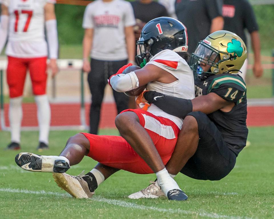 Trinity Catholic's Jeremiah Rhem (14) tackles Tampa Carrollwood Day's Bredell Richardson (1) during a game between Trinity Catholic High School and Tampa Carrollwood Day High School in Ocala on Friday, Sept. 15, 2023. [PAUL RYAN / CORRESPONDENT]