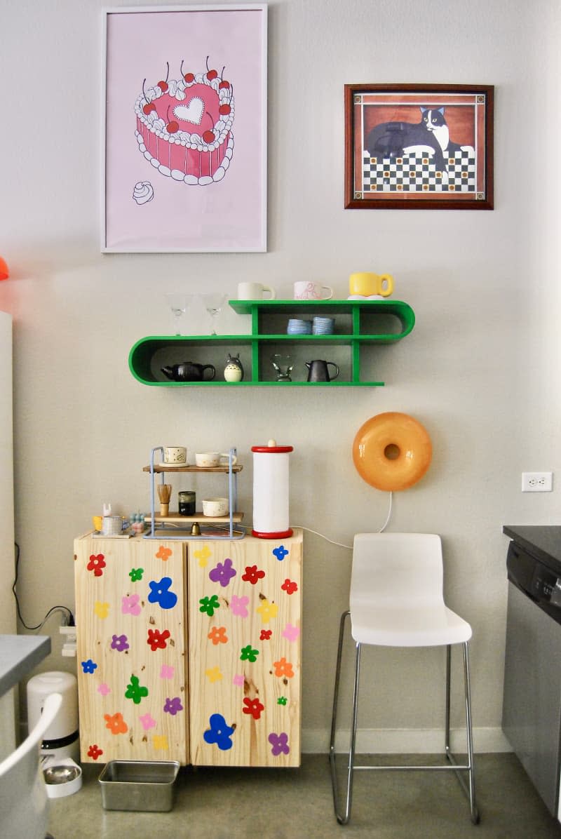 Green s-shaped shelf in kitchen area.