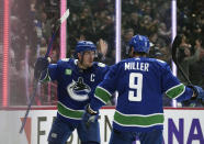 Vancouver Canucks' Bo Horvat, left, and J.T. Miller celebrate Horvat's goal against the Montreal Canadiens during the third period of an NHL hockey game in Vancouver, British Columbia, Monday, Dec. 5, 2022. (Darryl Dyck/The Canadian Press via AP)