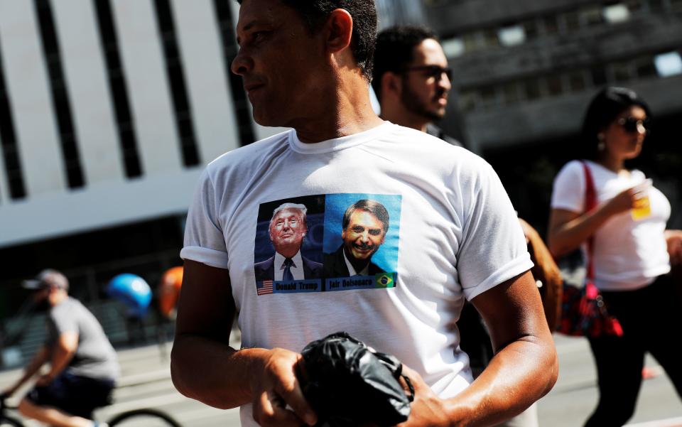A supporter of Brazilian presidential front-runner Jair Bolsonaro wears a T-shirt twinning with the candidate's image with that of U.S. President Donald Trump. (Photo: Nacho Doce / Reuters)
