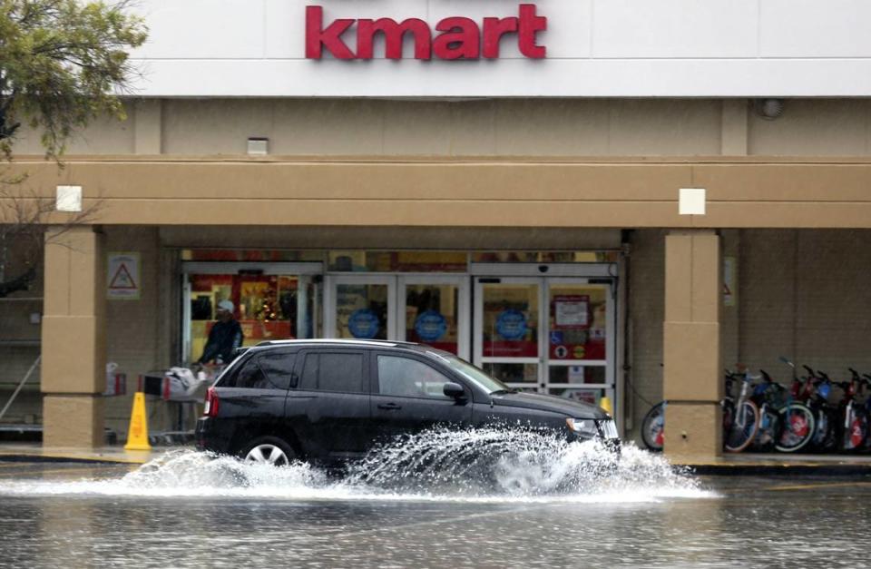 An SUV sends up a fan of water as splashes past the Kmart at 10700 Biscayne Blvd. in December 2015 when the area was under a flood watch.