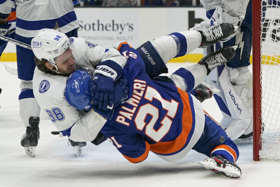 CORRECTS ID TO KYLE PALMIERI (21) NOT OTTO KOIVULA - Tampa Bay Lightning defenseman Mikhail Sergachev (98) and New York Islanders left wing Kyle Palmieri (21) fight during the second period of Game 3 of the NHL hockey Stanley Cup semifinals, Thursday, June 17, 2021, in Uniondale, N.Y. (AP Photo/Frank Franklin II)