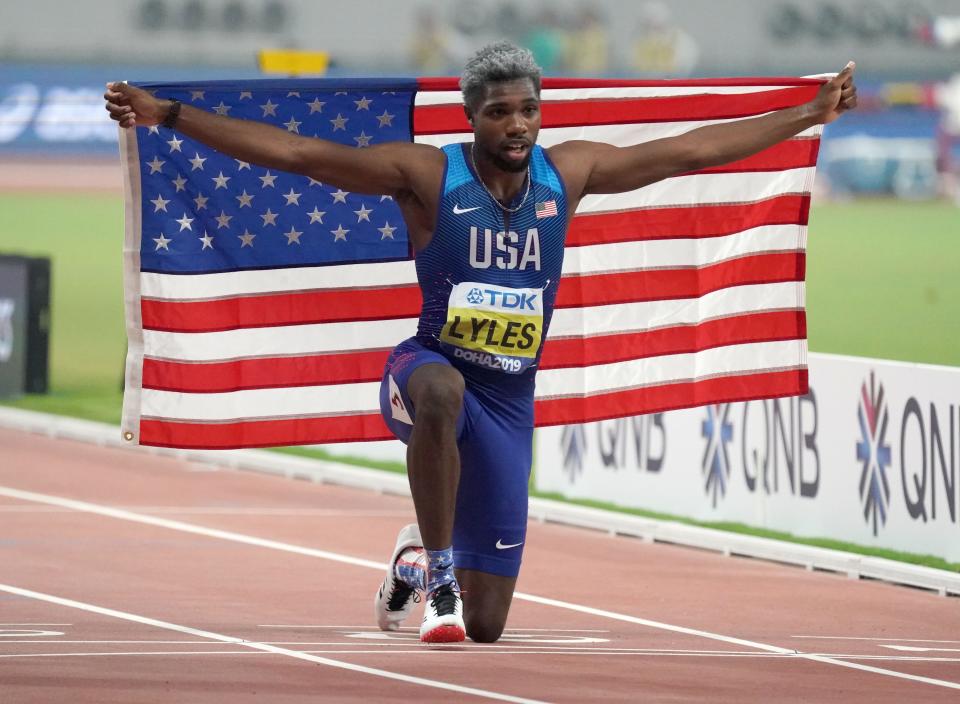 Noah Lyles poses with the United States flag after winning the 200m in 19.83 during the IAAF World Athletics Championships at Khalifa International Stadium.