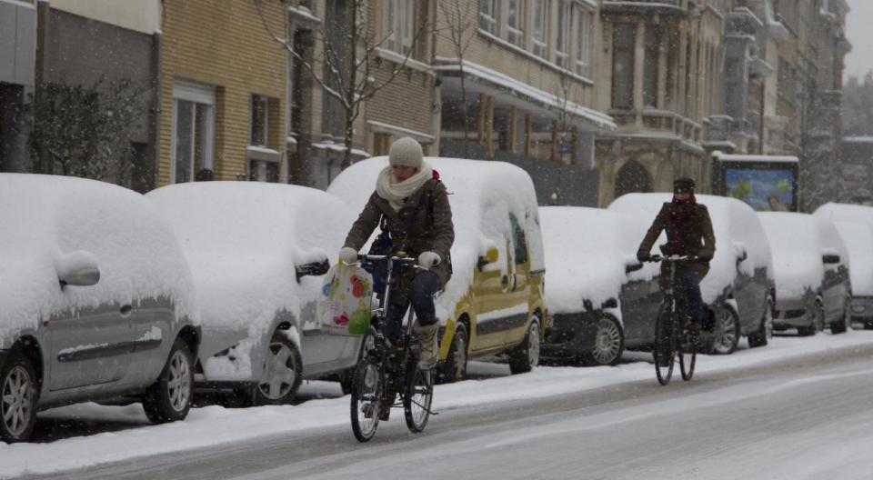 People ride their bicycles on an icy road in Antwerp, Belgium on Tuesday, March 12, 2013. An overnight snowfall on Monday evening snarled rush hour traffic on Tuesday morning. (AP Photo/Virginia Mayo)