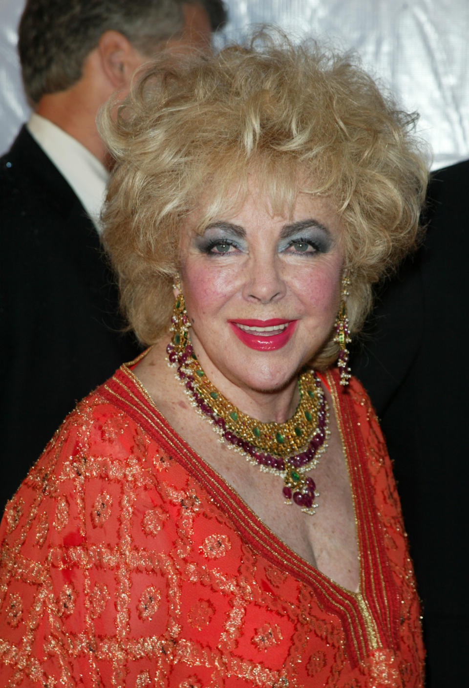 Elizabeth Taylor in an embellished orange dress with statement jewelry