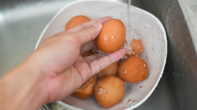 person washing eggs