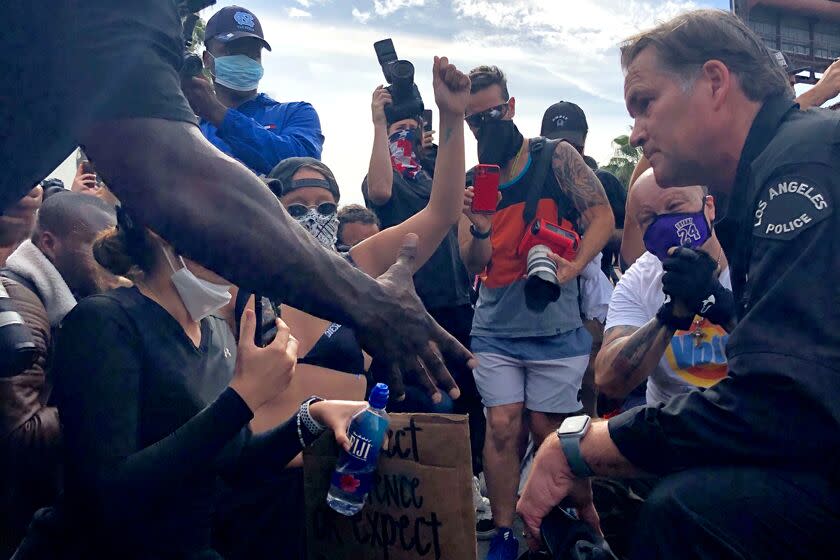 LAPD Cmdr. Cory Palka of the Operation West Bureau asked protesters Monday in West Hollywood that if he took the knee, would they agree to make the protest peaceful. He heard screams of support, then dropped to his knee to more applause.