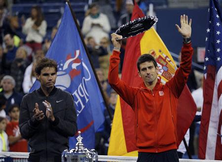 Rafael Nadal of Spain applauds as Novak Djokovic of Serbia raises his runner up trophy after Nadal won their men's final match at the U.S. Open tennis championships in New York, September 9, 2013. REUTERS/Ray Stubblebine