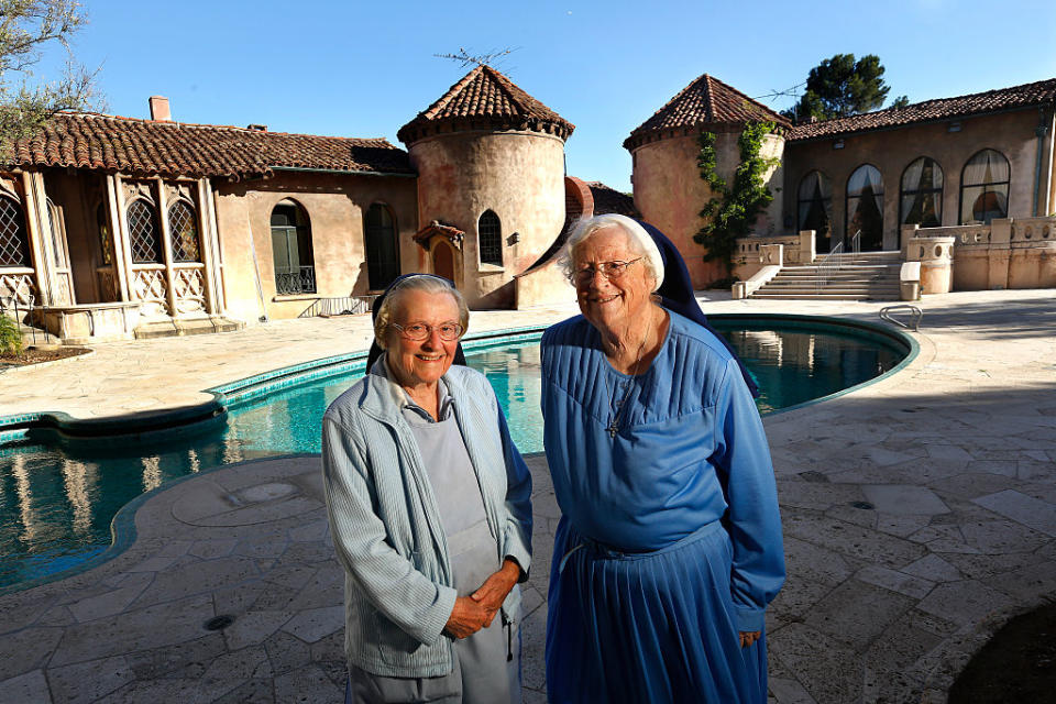 two elder two standing outside the large convent