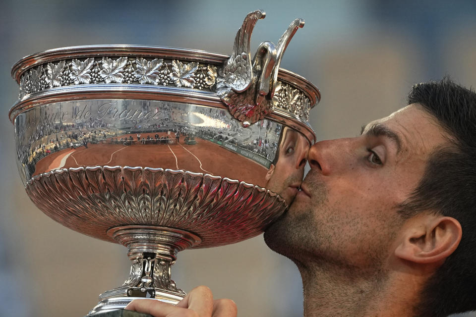 FILE - Serbia's Novak Djokovic kisses the cup after defeating Stefanos Tsitsipas of Greece during their final match of the French Open tennis tournament at the Roland Garros stadium, Sunday, June 13, 2021 in Paris. Djokovic won 6-7 (6), 2-6, 6-3, 6-2, 6-4. Rafael Nadal and Novak Djokovic are both entered in the French Open, making it the first Grand Slam tournament with both of them in the field since last year’s French Open. (AP Photo/Michel Euler, File)