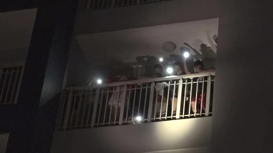 Bewohner eines Wohnkomplexes rufen mit den Lichtern ihrer Mobiltelefone um Hilfe nach dem Ausbruch eines Feuers. Foto: VnExpress