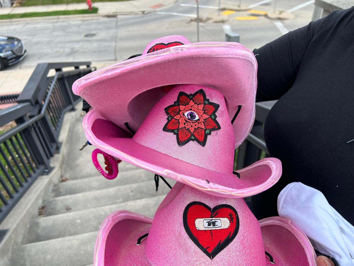 Tawana Harris of Milwaukee holds pink cowboys hats that she made and brought to a vigil for Sade Robinson held Friday night. Harris worked with Robinson at Pizza Shuttle and described her as her "spiritual daughter."