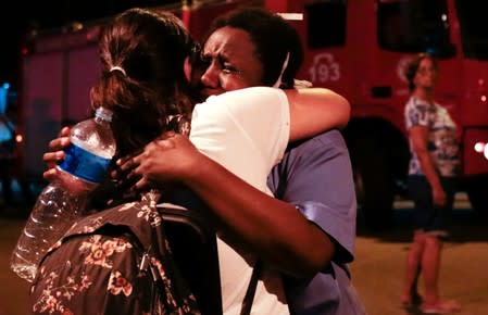 People react after a fire hit the Badim Hospital in Rio de Janeiro