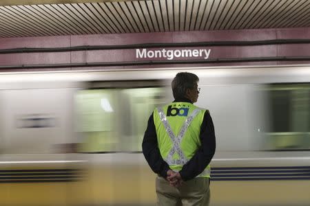 A Bay Area Rapid Transit (BART) official watches as a train moves through the Montgomery Station without stopping, in San Francisco, California January 16, 2015. REUTERS/Robert Galbraith