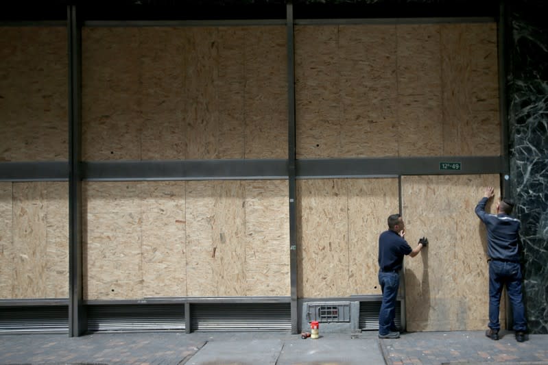 The facade of a bank is covered with wood sheets, one day before a national strike in Bogota