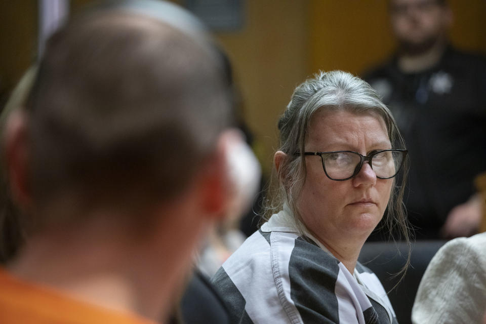 Person in courtroom looking over shoulder with concerned expression