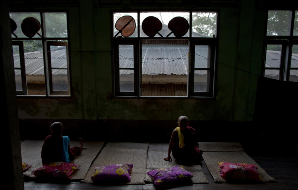 In this April 8, 2014 photo, newly ordained Buddhist novices sit on mats at a Buddhist monastery in suburbs of Yangon, Myanmar. In addition to learning the basic tenants of their faith, it serves as a sort of spiritual credit for their parents, helping emancipate them from a viscous cycle of rebirth and death. (AP Photo/Gemunu Amarasinghe)